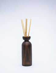 insense sticks in a dark bottle on a white background