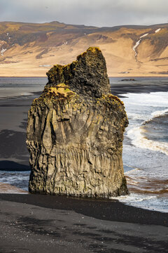 Close-up of the impressive Arnardrangur basalt rock formation on the black sand of Reynisfjara beach, Iceland, viewed from Dyrh&oacute;laey, near Route 1 / Ring Road