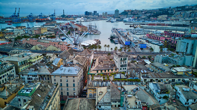 Drone view from Genoa's old town looking out over the Porto Antico and industrial harbor in Italy. An aerial perspective from the historic city.