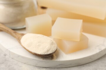 Gelatin powder and jelly pieces on gray table, closeup