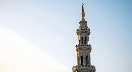 Obraz premium Close-up view of a tall minaret tower against a bright sky, showcasing Islamic architecture