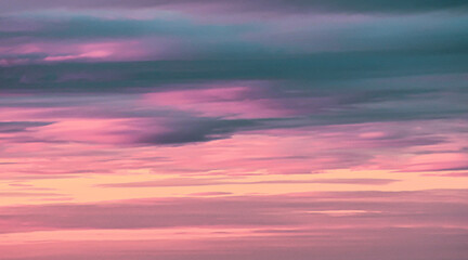 Fototapeta premium Vibrant magenta and cyan sunset sky with soft cloud layers