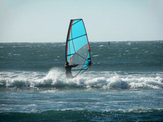 Man windsurfing, battling the wind and waves