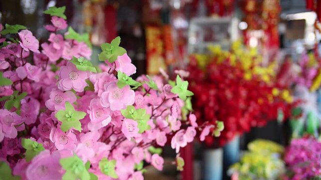 Colorful red and golden decorative elements sold on an vietnamese street market prior to the Tet holiday or Lunar new year in Vietnam, Asia. Selective focus close up video.