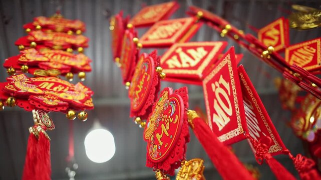 Colorful red and golden decorative elements sold on an vietnamese street market prior to the Tet holiday or Lunar new year in Vietnam, Asia. Selective focus close up video.