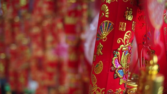 Colorful red and golden decorative elements sold on an vietnamese street market prior to the Tet holiday or Lunar new year in Vietnam, Asia. Selective focus close up video.