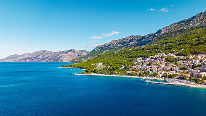 Scenic Croatian Riviera destination featuring crystal clear waters, rocky coastline, harbor,...