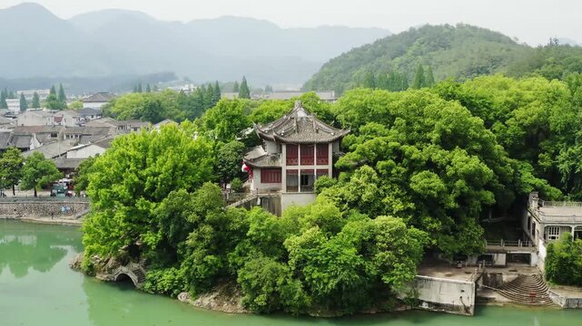 Ancient Chinese Pagoda on Island Surrounded by Lush Green Mountains
