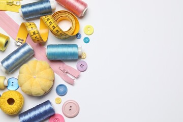 Flat lay composition with sewing supplies on white background. Space for text