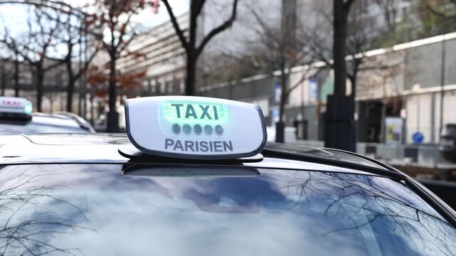 Le logo des taxis de Paris sur une voiture dans la rue.