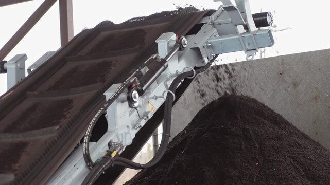 Processing of organic waste, compost plant. Compost plant equipment processes organic waste, and ready-made stabilized organic fertilizer is sifted through a sieve.