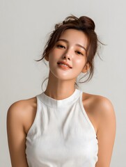 Serene young woman in white sleeveless top.