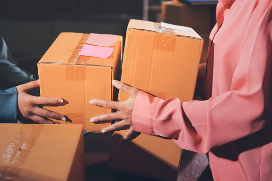 Startup SME small business entrepreneur of freelance Asian woman wearing apron using laptop and box to receive and review orders online to prepare to pack sell to customers, online sme business ideas.