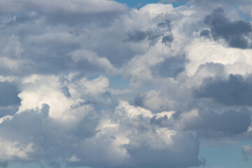 Obraz premium Dramatic Overcast Sky With Layered Cumulus Clouds, Sunlit Patches And Blue Background