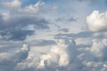 Obraz premium Dramatic Overcast Sky With Layered Cumulus Clouds, Sunlit Patches And Blue Background