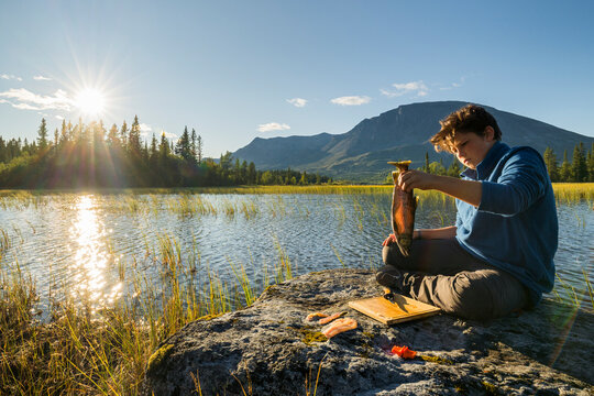ein Junge filetiert eine Bachforelle, Helsingvatnet, Hemsedal, Buskerud, Norwegen