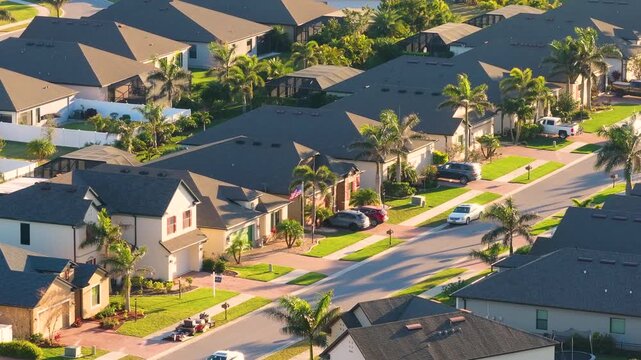 Gated community with expensive houses between green palm trees in southwest Florida. Premium housing development in the USA.