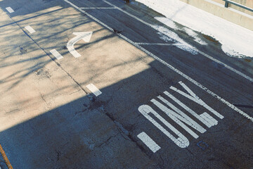 Fototapeta premium Road marked for one-way traffic with a left turn option at a city intersection during daytime
