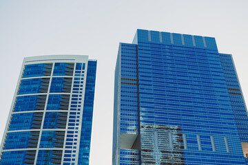 Skyscraper buildings with glass fronts and reflections in the city during daylight