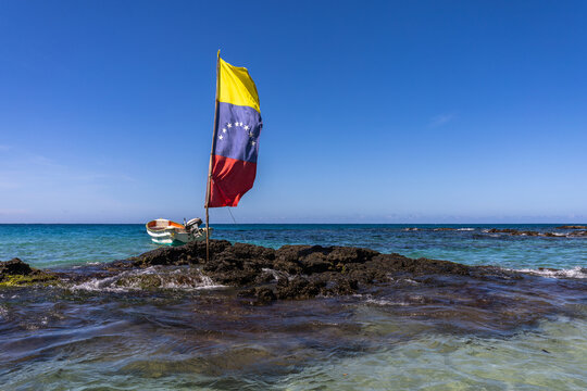 Venezuelan Flag Waving Over Turquoise Waters with Fishing Boat