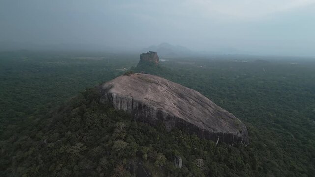 Stunning aerial descending view Pidurangala Rock and Sigiriya rock rising above the lush green jungle in Sri Lanka Cultural Triangle