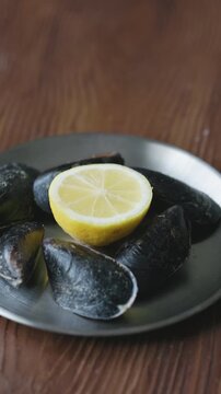 Close-Up of Turkish Stuffed Mussels Served with Lemon on Metal Plate
