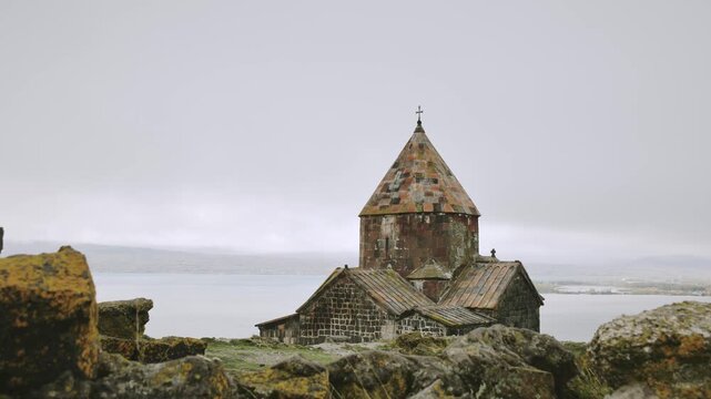 Zoom in Timelapse Sevanavank monastic complex building with Sevan lake. Peninsula at the northwestern shore of Lake Sevan in the Gegharkunik Province of Armenia. Popular travel sightseeing attraction