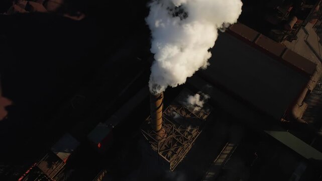 Factory smokestack releasing toxic emissions in the air. Industrial pollution affects land, water, and atmosphere. Greenhouse gas emissions environmental damage air quality issues industry concept.