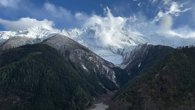 Cinematic view of snow-capped Annapurna Mountains, Nepal, with glaciers and time-lapse clouds