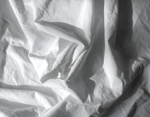 Soft white fabric draped elegantly, highlighting texture and folds for textile and interior design contexts.