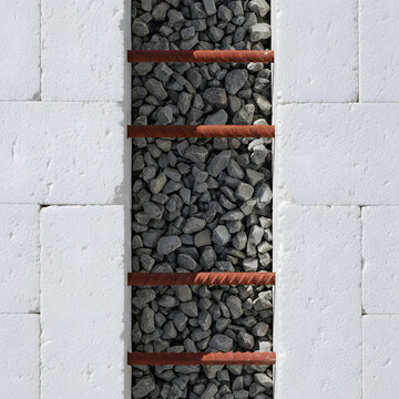 A top-down view shows gray gravel stones packed between white blocks and secured with horizontal rusty rebar rods in a construction setting. Generative AI