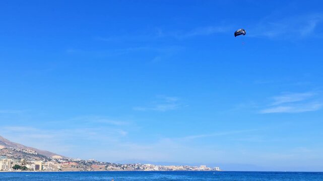 Paraglide flying in the blue sky