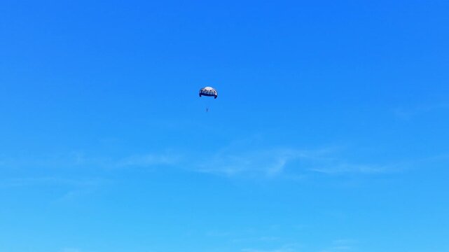 Paraglide flying in the blue sky