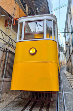 The iconic yellow funicular climbing a narrow, steep street, a classic symbol of Portuguese urban transport