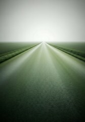 Serene road through green fields leading to a foggy horizon vista