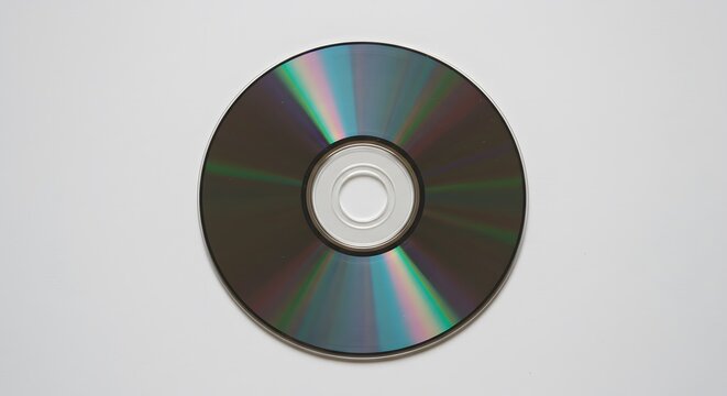 Silver compact disc with iridescent sheen on a white surface
