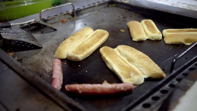 Close up shot of bread slices toasting on a flat top grill during street food sandwich preparation.