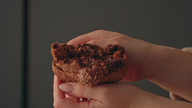 Close up hands splitting baked chocolate cookie indoors