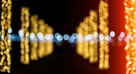 Abstract panorama of glowing golden bokeh lights on a dark background creating a magical and festive atmosphere for celebrations