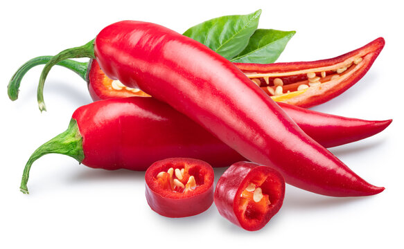 A vibrant arrangement of red chili peppers including whole and sliced specimens on a white background