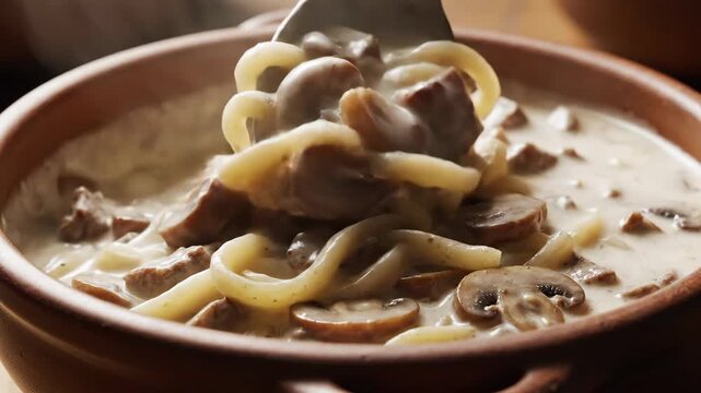 Creamy beef stroganoff with mushrooms being stirred in bowl 4K Video