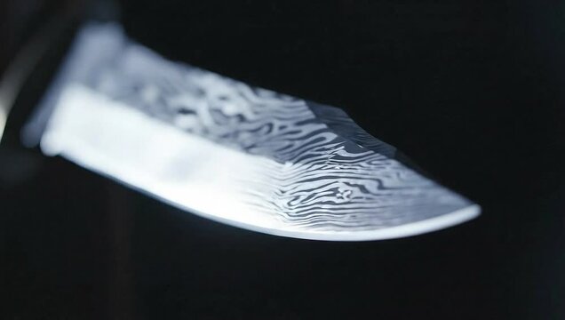 Close-Up of a Damascus Steel Knife Blade with Intricate Patterns.