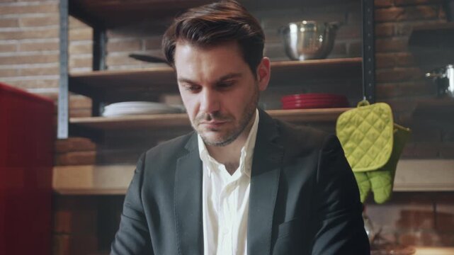 Man reviews kitchen documents, Individual dressed professionally reviews arrangement and items in kitchen area