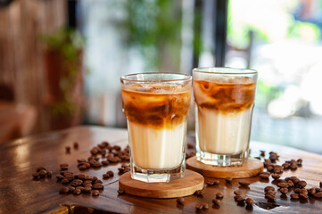 Mrożona kawa z mlekiem na stole w kawiarni posypanym ziarnami kawy