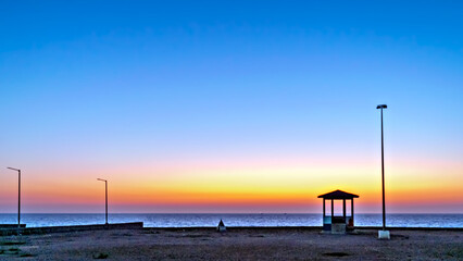 Obraz premium Beautiful sunset on background of hut on the sea shore of Veraval, Gujrat, India