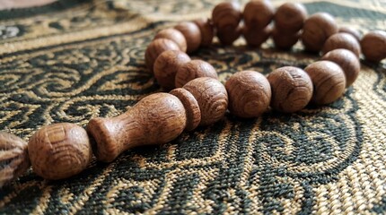 Close-up of Traditional Wooden Prayer Beads on Ornate Fabric