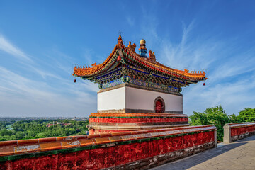 Obraz premium Traditional Chinese Pagoda with Ornate Roof and Cultural Architecture Against Blue Summer Sky
