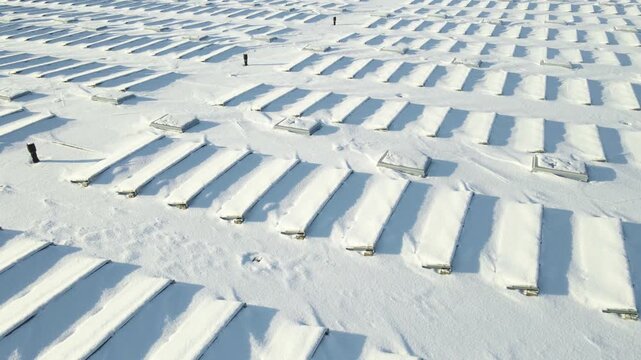 Drone pass over rooftop arrays fully buried in fresh snow, highlighting extreme weather impact on renewable generation.