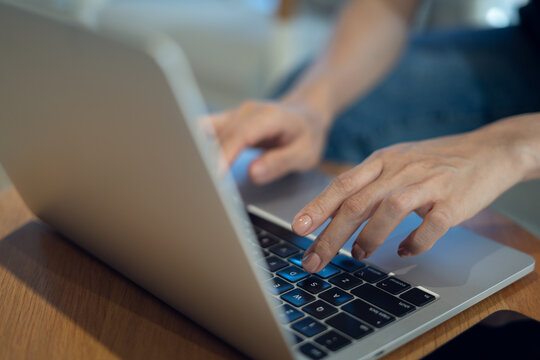 Close up of casual business woman hands typing on laptop computer on table, searching the information and surfing the internet, remote working, telecommuting, freelance at work