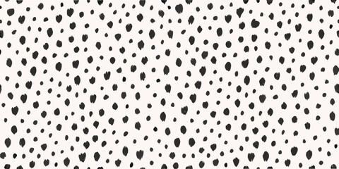 Abstract background of scattered irregular black shapes on a white surface